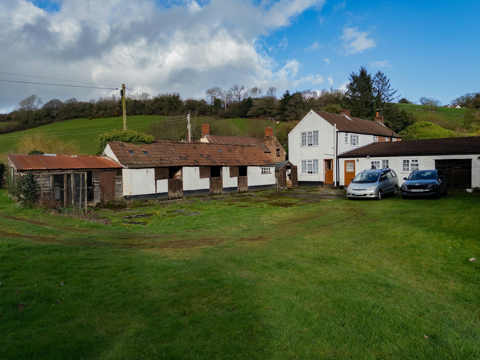 Rural houses with cars parked outside on grassy yard
