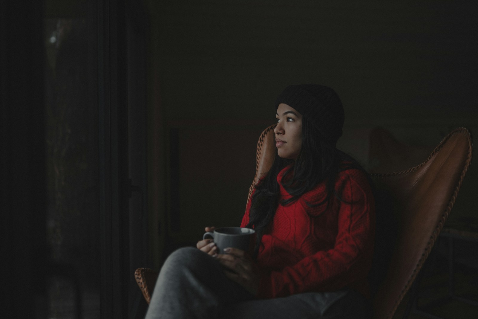 a woman sitting in a chair holding a cup of coffee