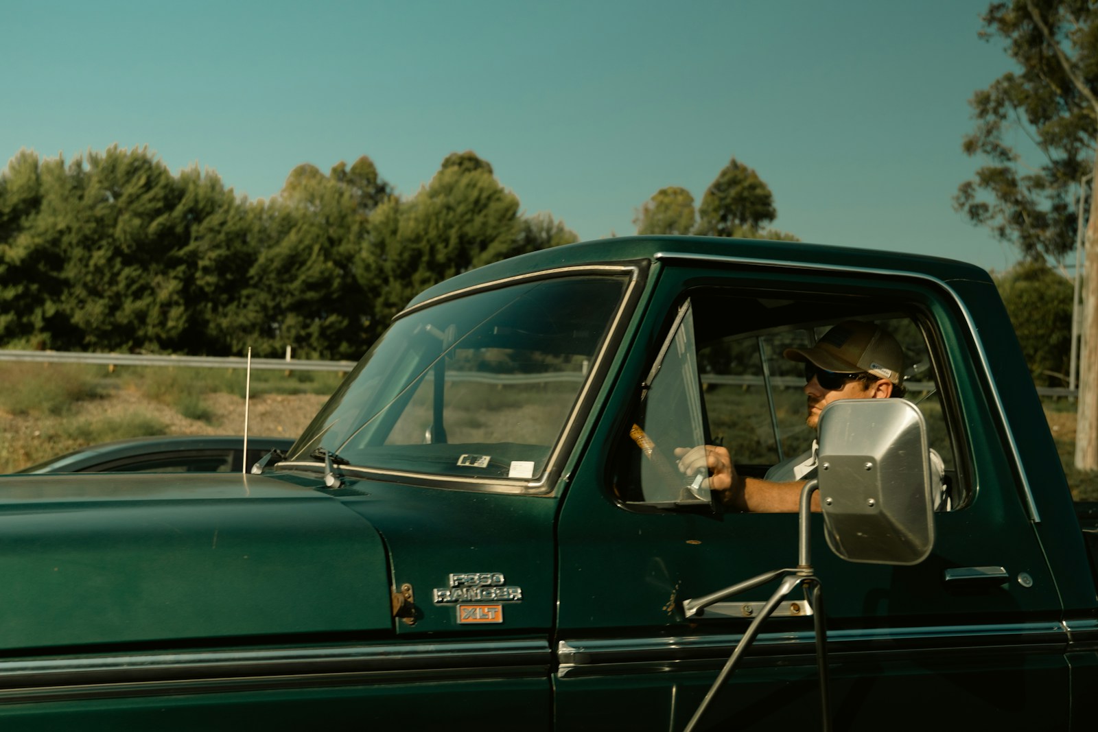 Man driving a green vintage pickup truck