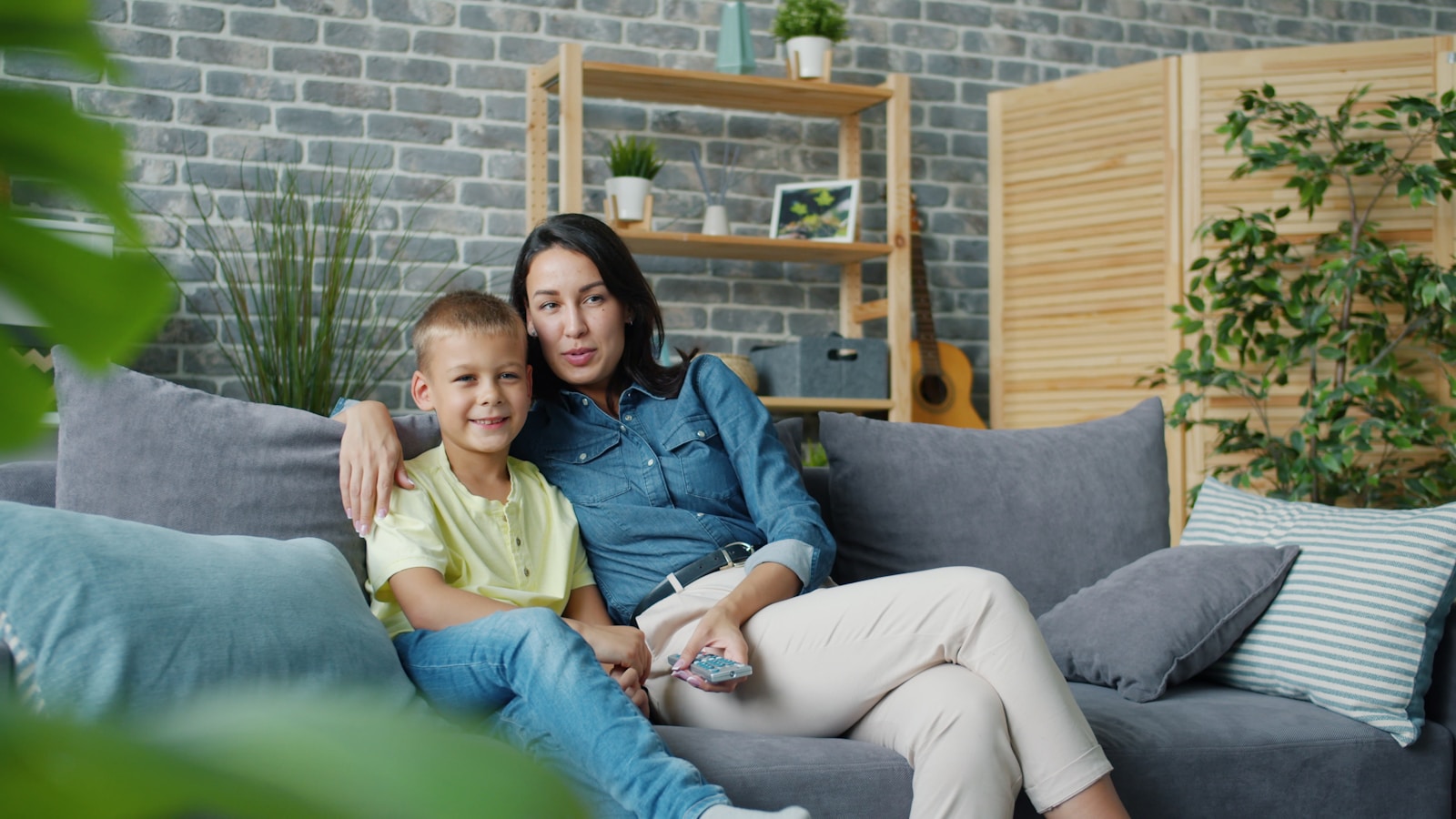 Mother and son sitting together on a couch.