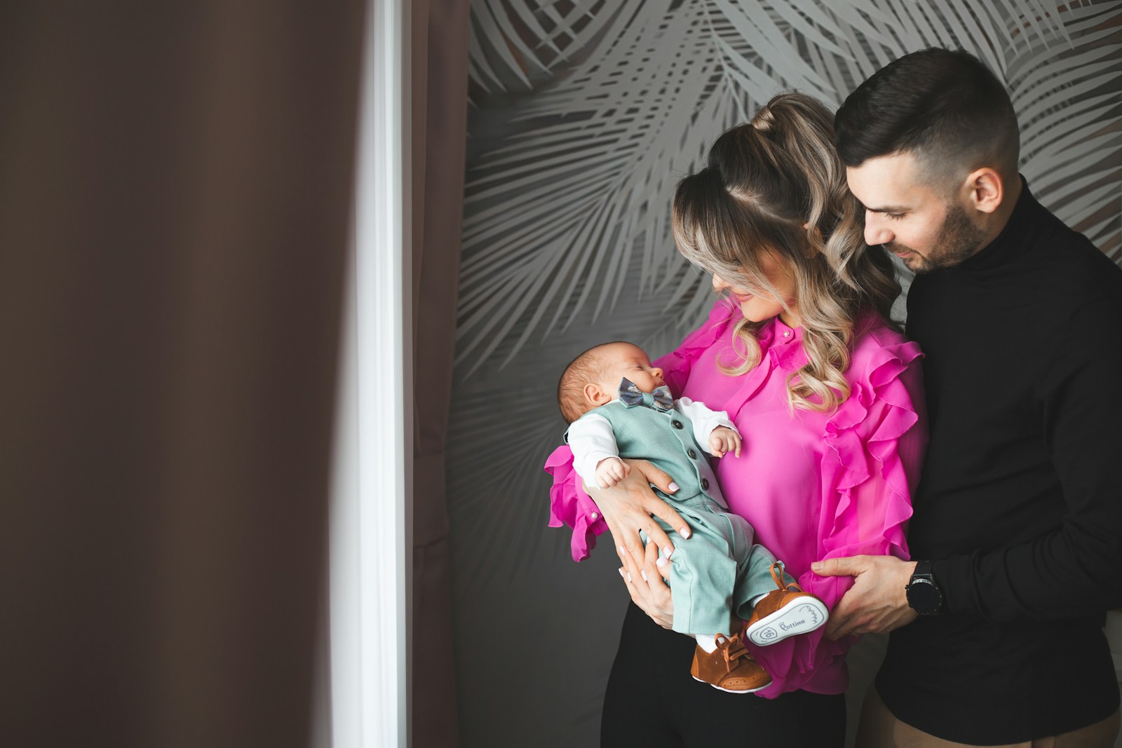Parents holding their newborn baby together