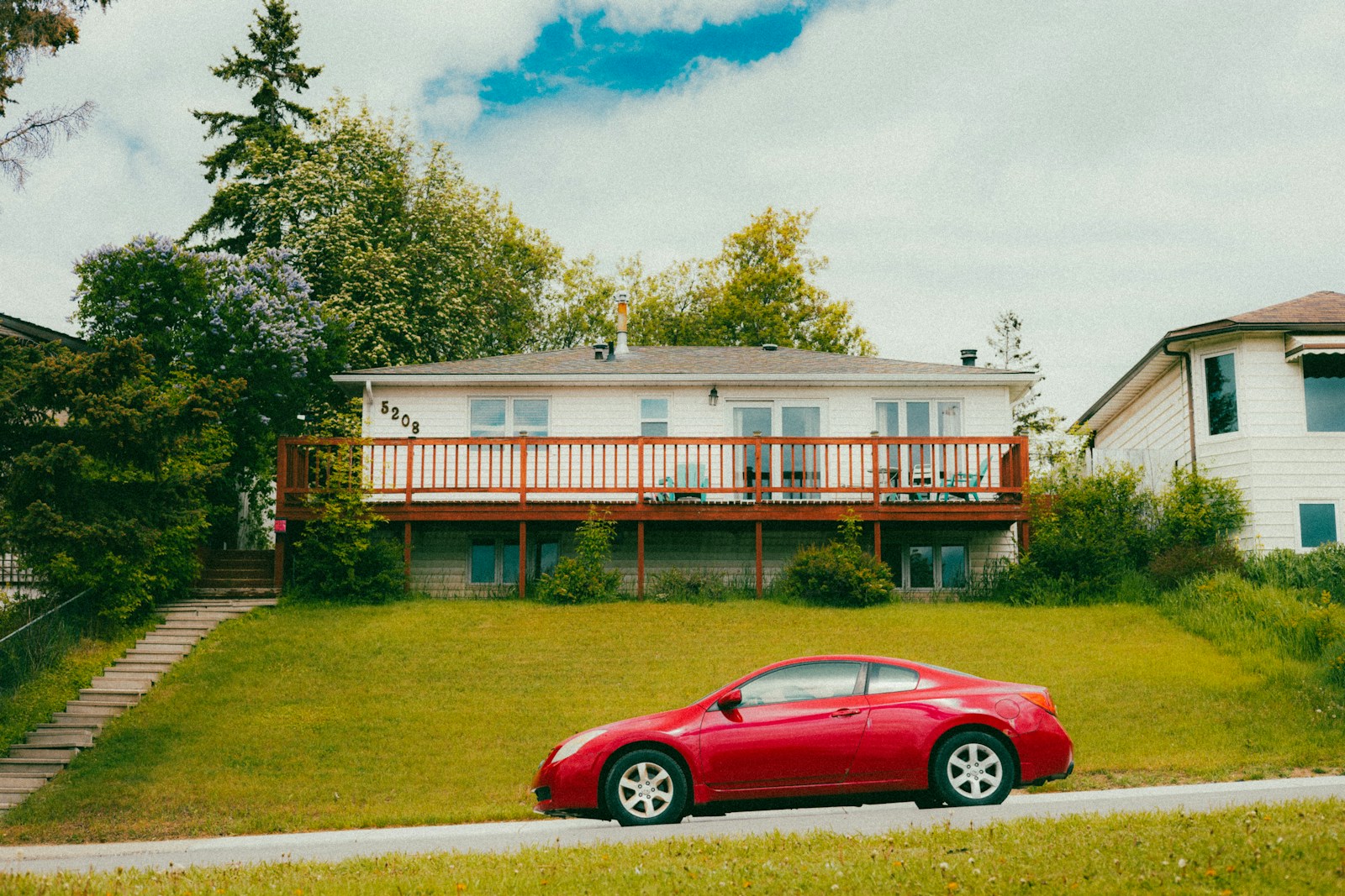 A red car parked in front of a house