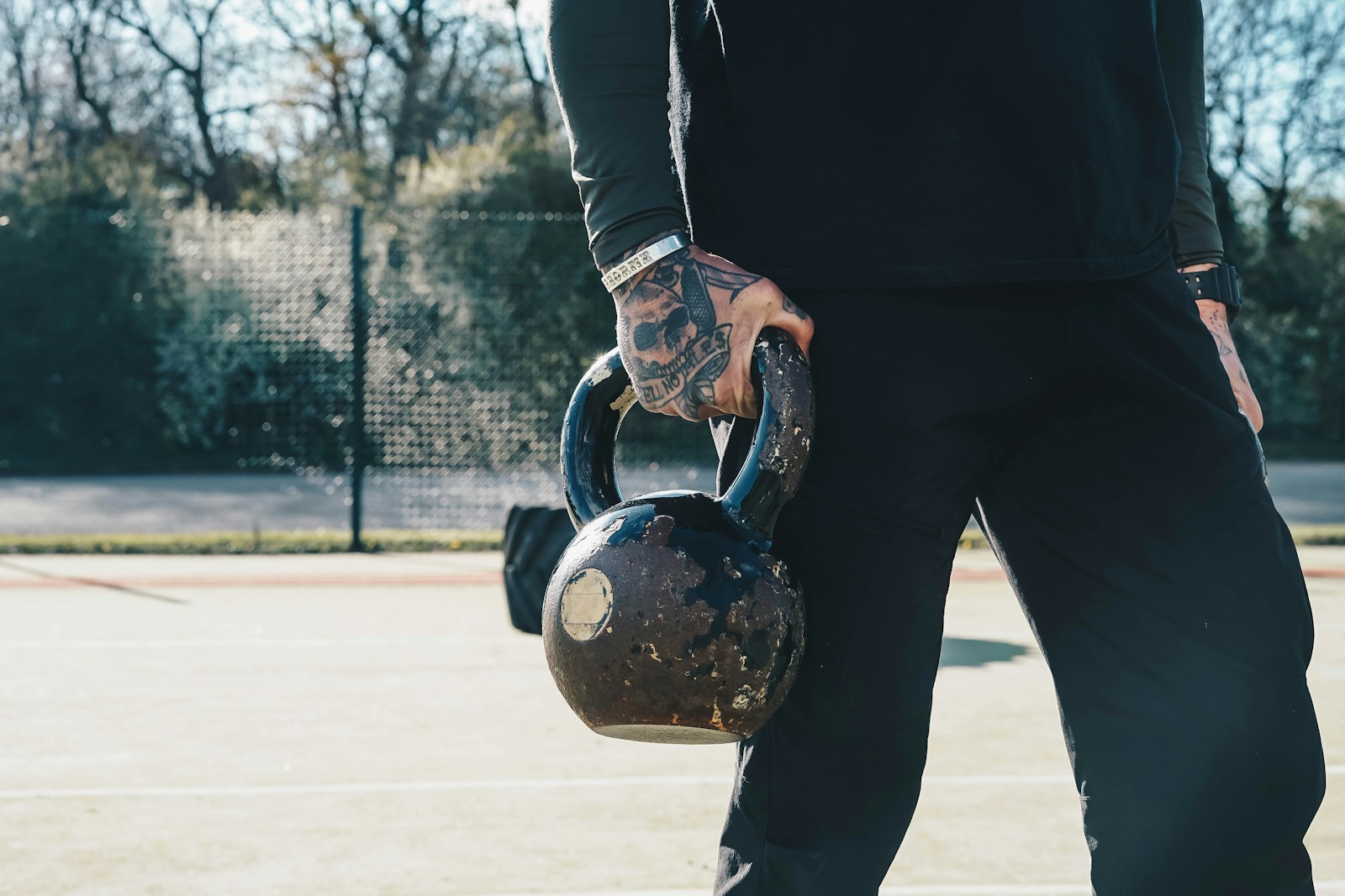 a man holding a kettle on a tennis court