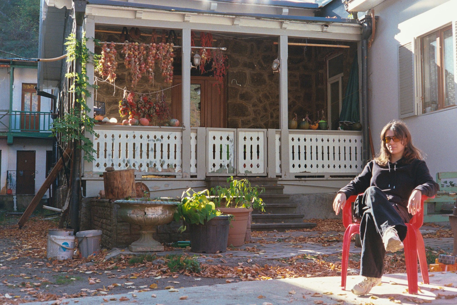 Woman sitting in red chair outside rustic house