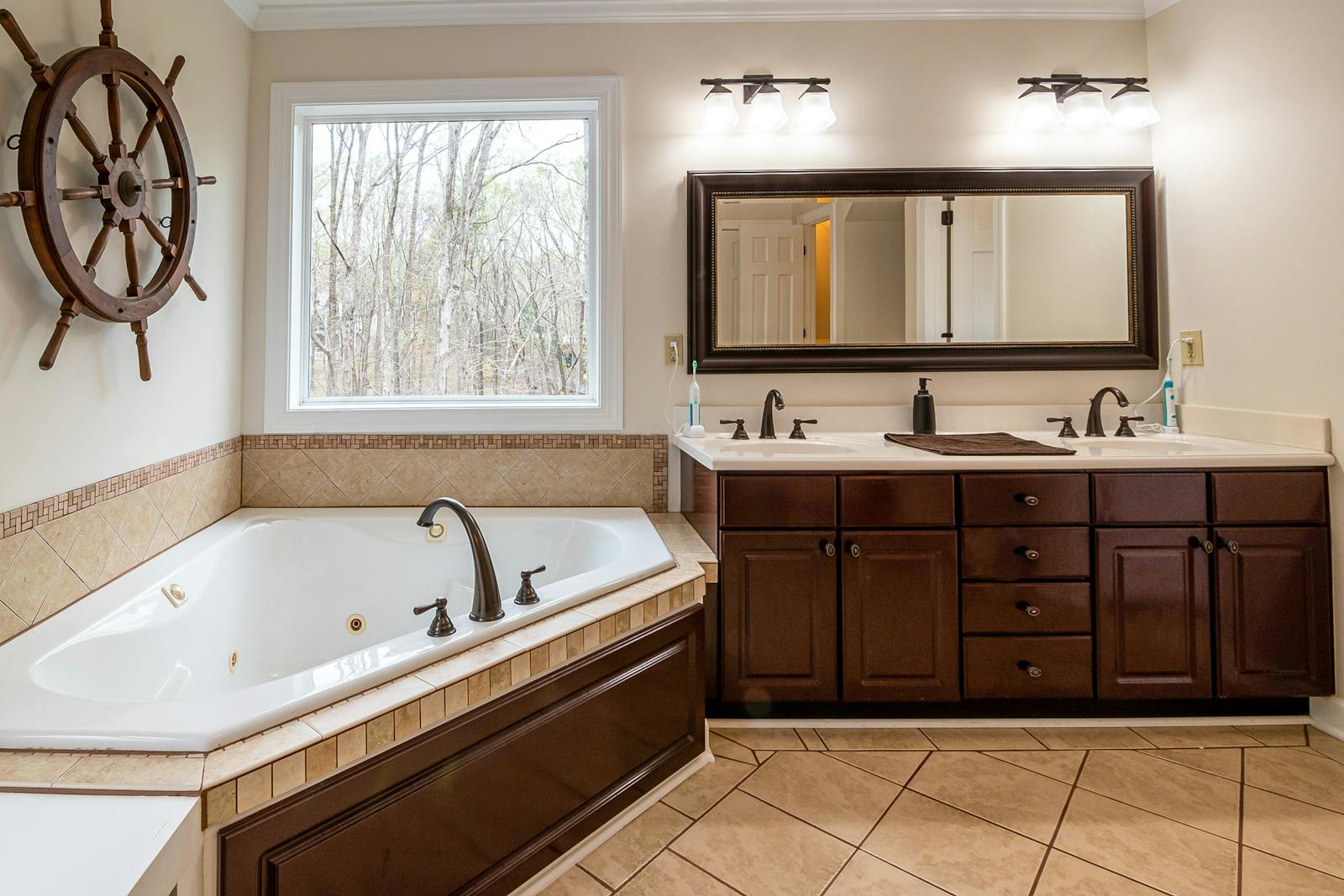 Elegant bathroom design featuring a whirlpool tub and double vanity with wooden cabinets.