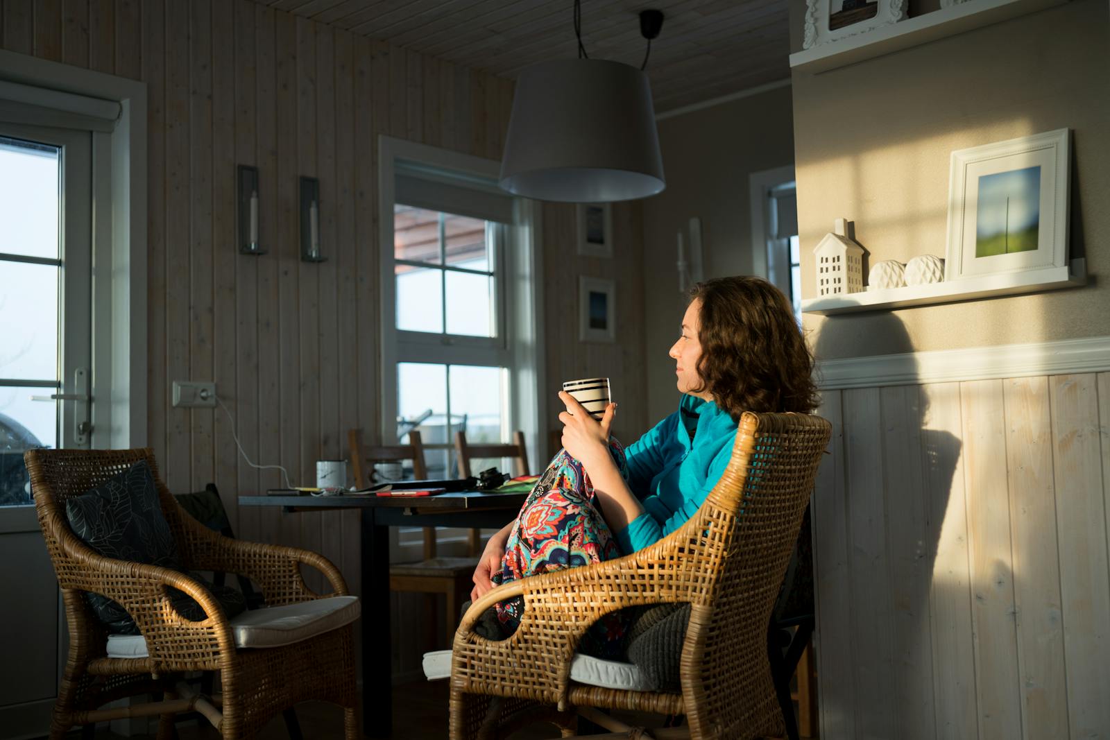 Woman enjoying a peaceful moment with coffee in a cozy living room setting.