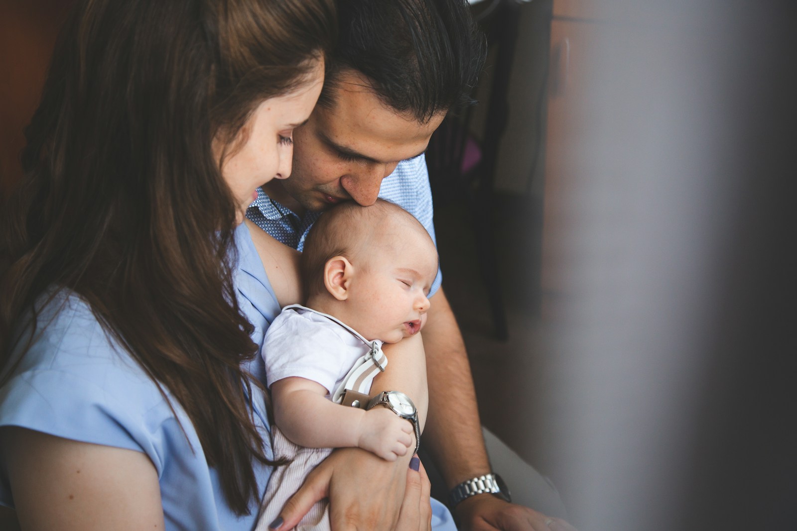 Parents holding their sleeping newborn baby