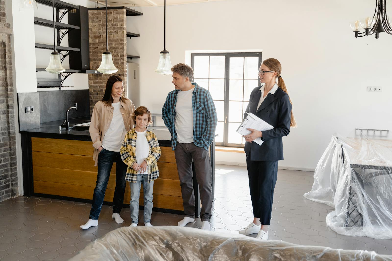 Family exploring a newly purchased home interior with real estate agent.
