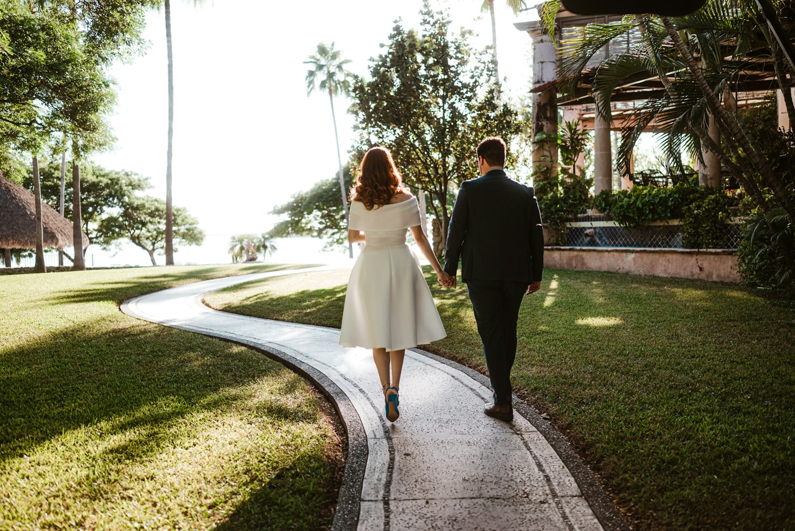 Couple walking on a winding path in a tropical garden.