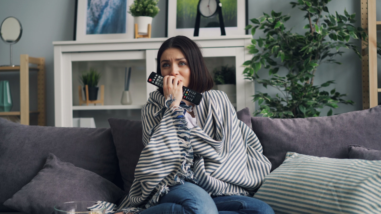 a woman sitting on a couch holding a camera