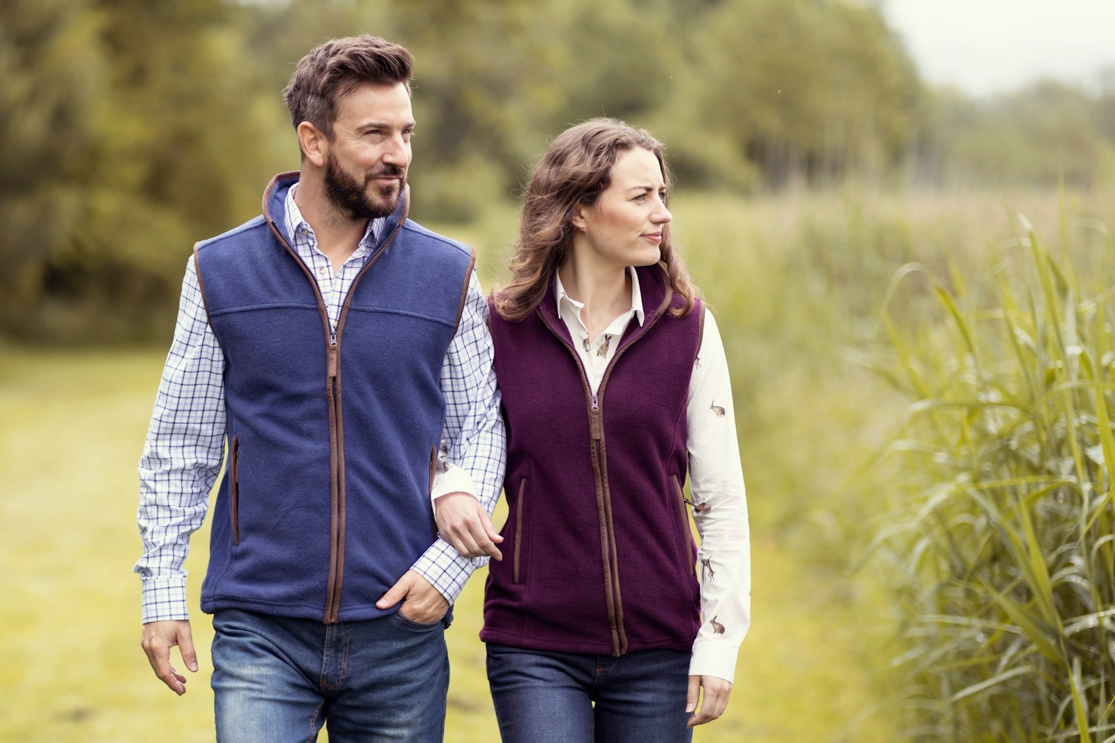 a man and a woman walking through a field