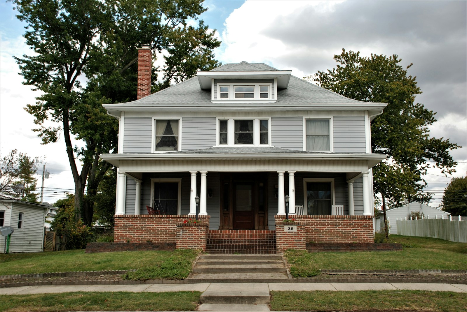 white and brown concrete house near green grass field during daytime