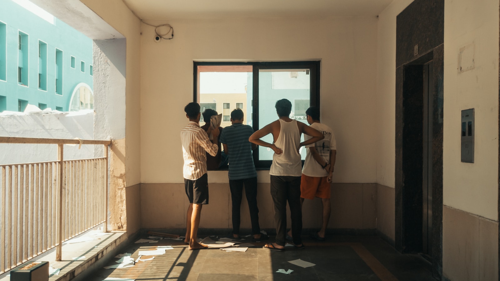 Four young men looking out a window together