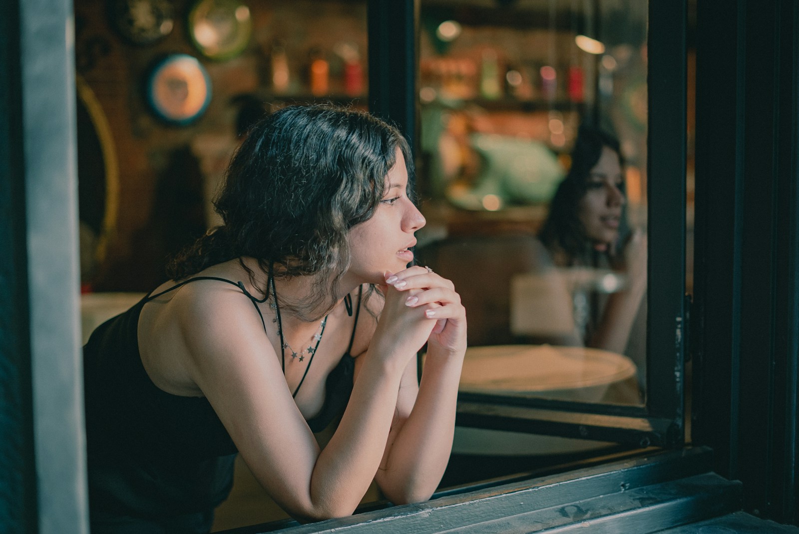 a woman sitting on a window sill looking out the window