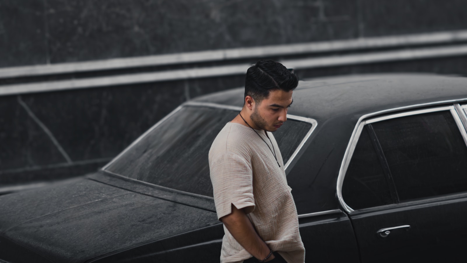 A man standing next to a black car