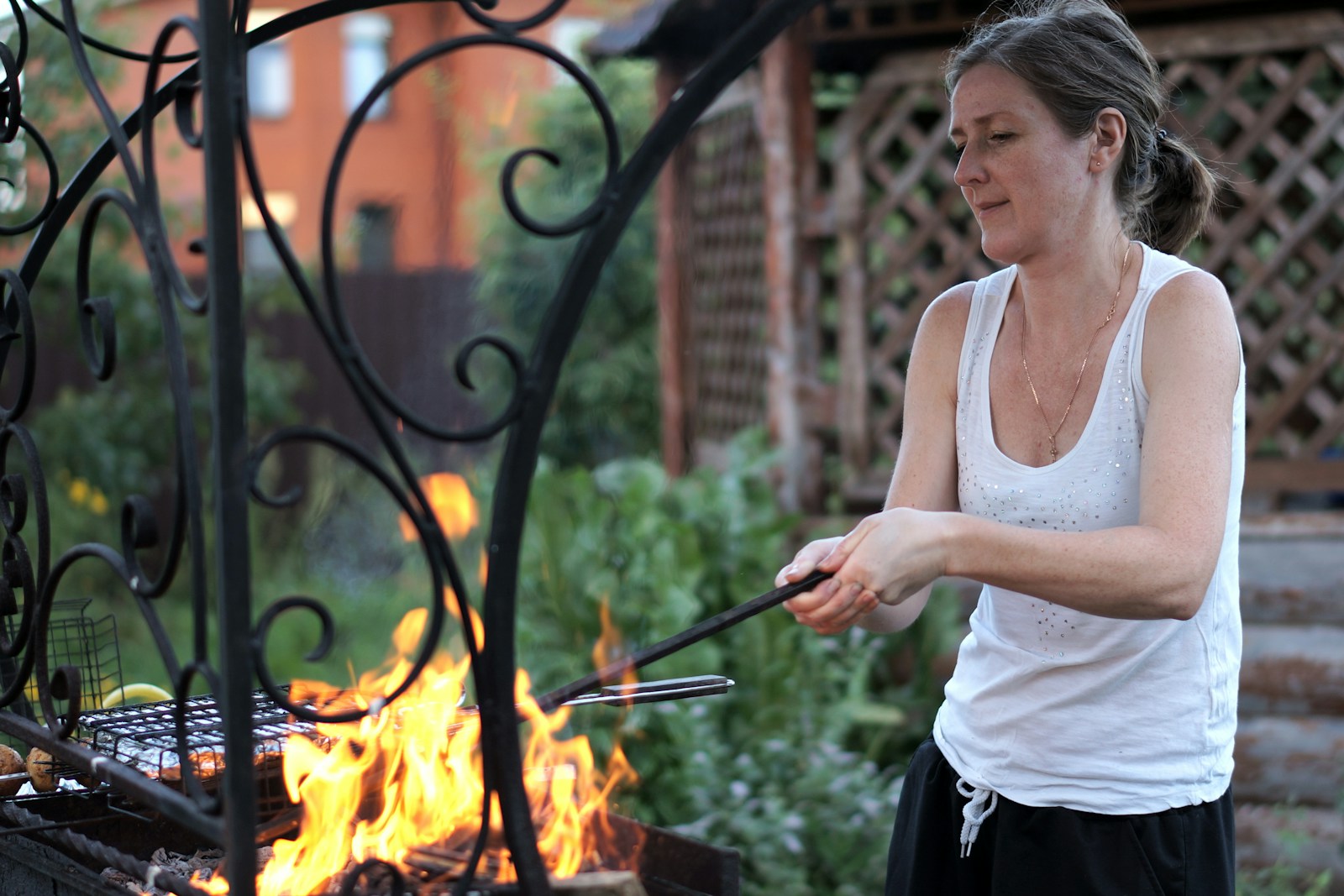 A woman is cooking on a grill outside