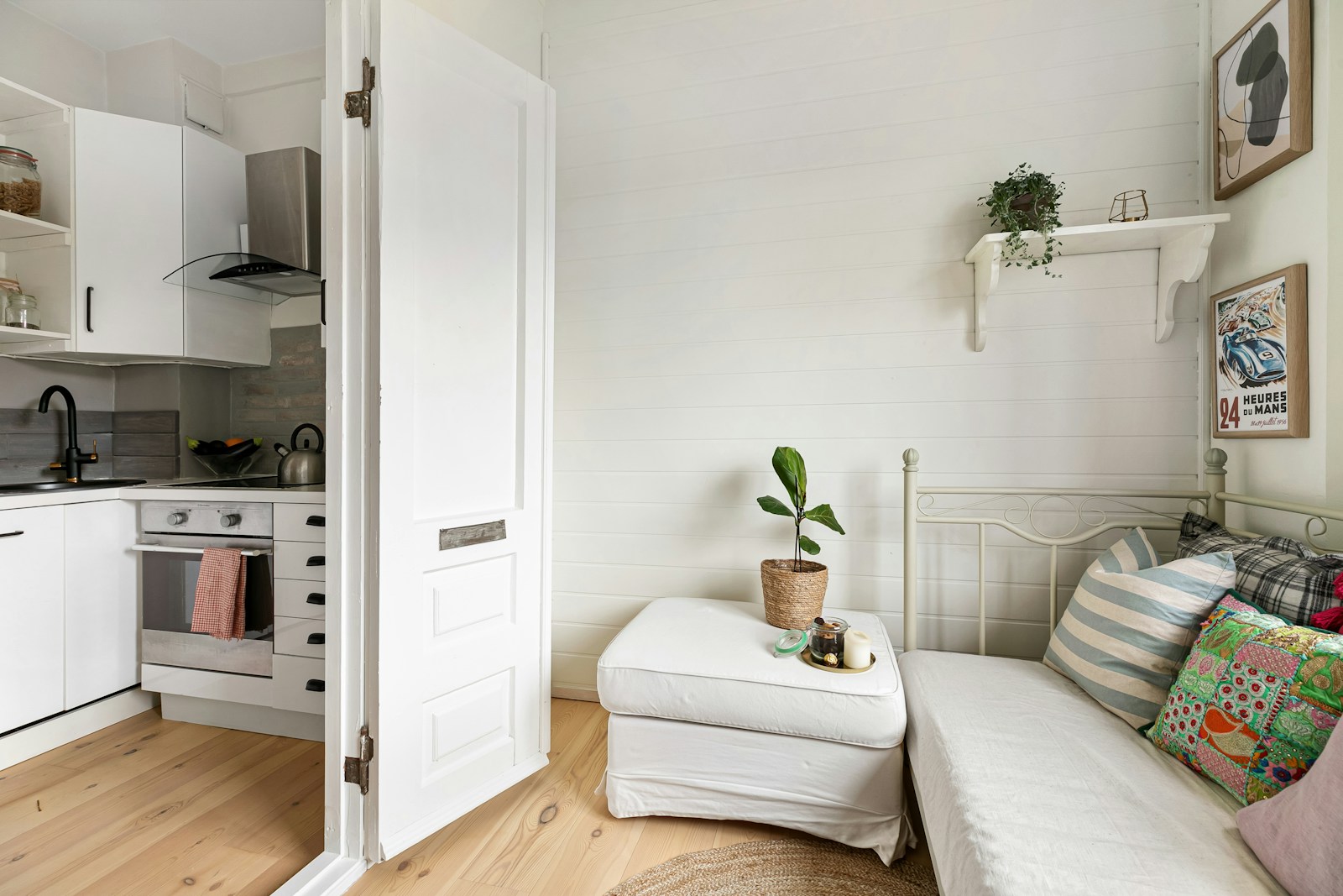 A kitchen with a white couch and a white refrigerator