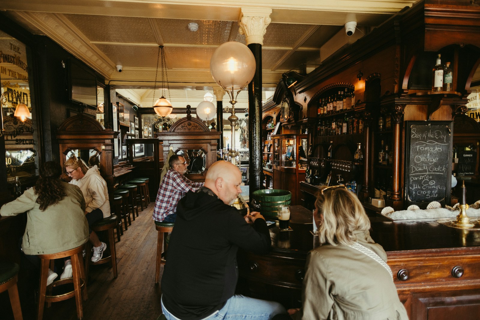 People enjoying drinks in a traditional pub interior.