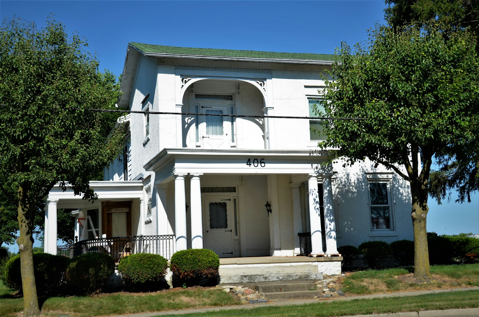 a white house with trees and bushes