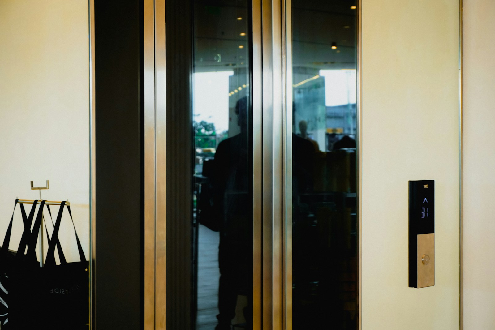 Modern elevator doors with a person's reflection.