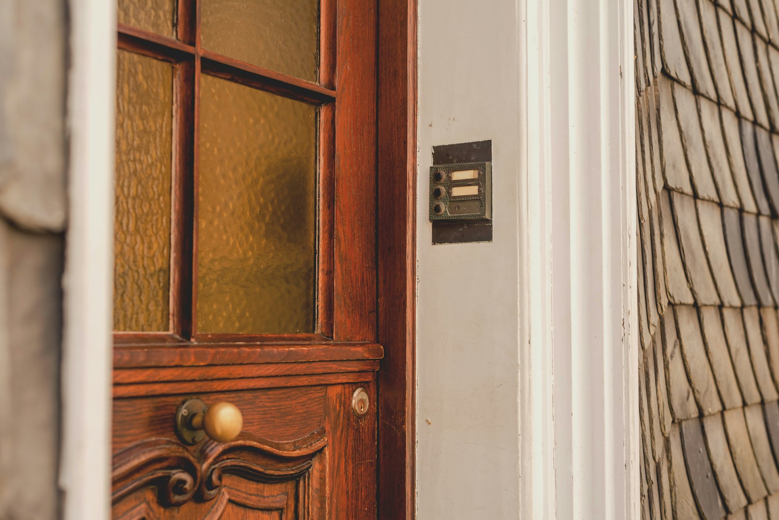 Close-up of a wooden door with a doorbell