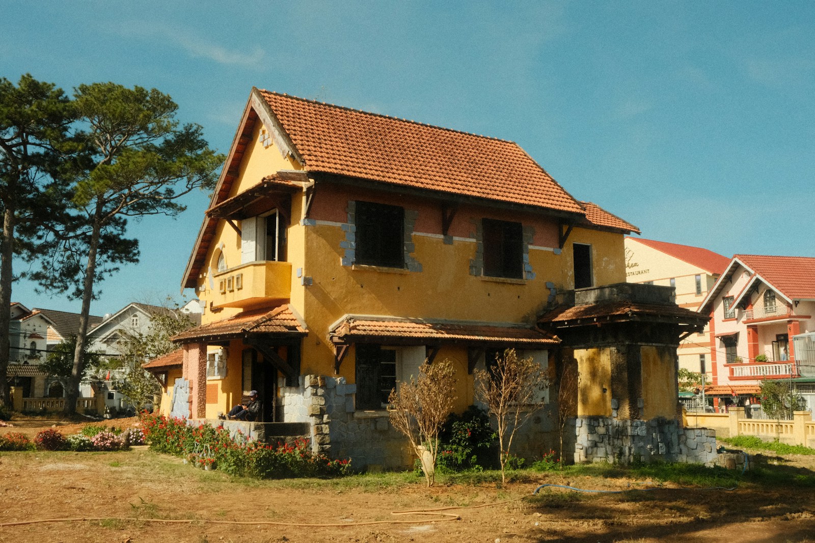A weathered yellow house with an orange roof