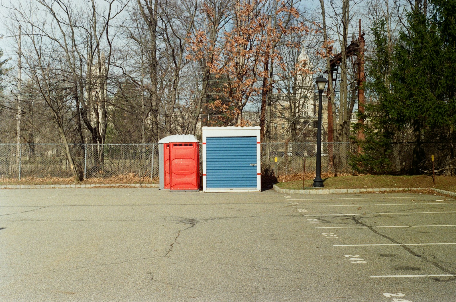 A red portable toilet and blue storage unit.