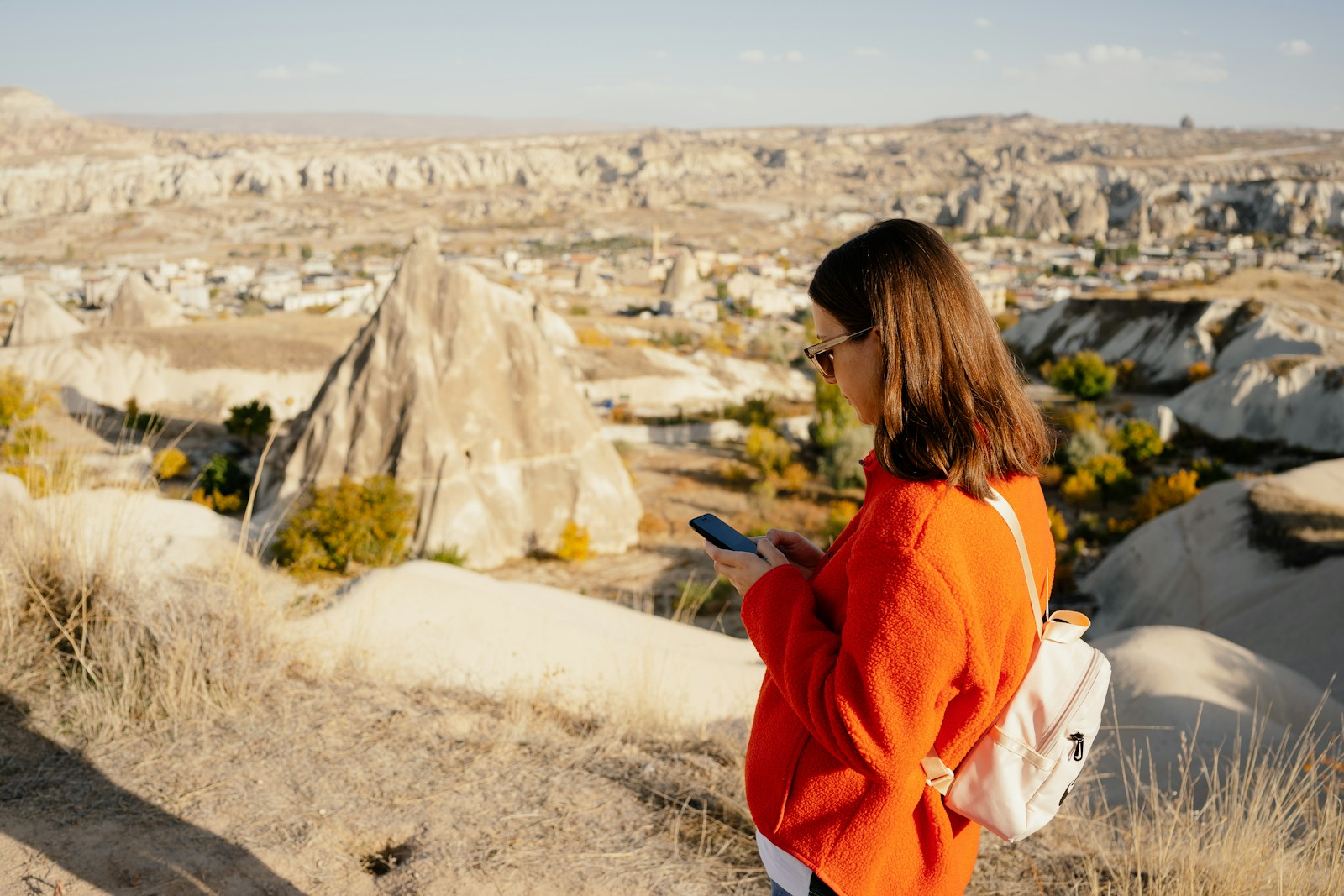a person looking at the phone with Cappadocia in the background