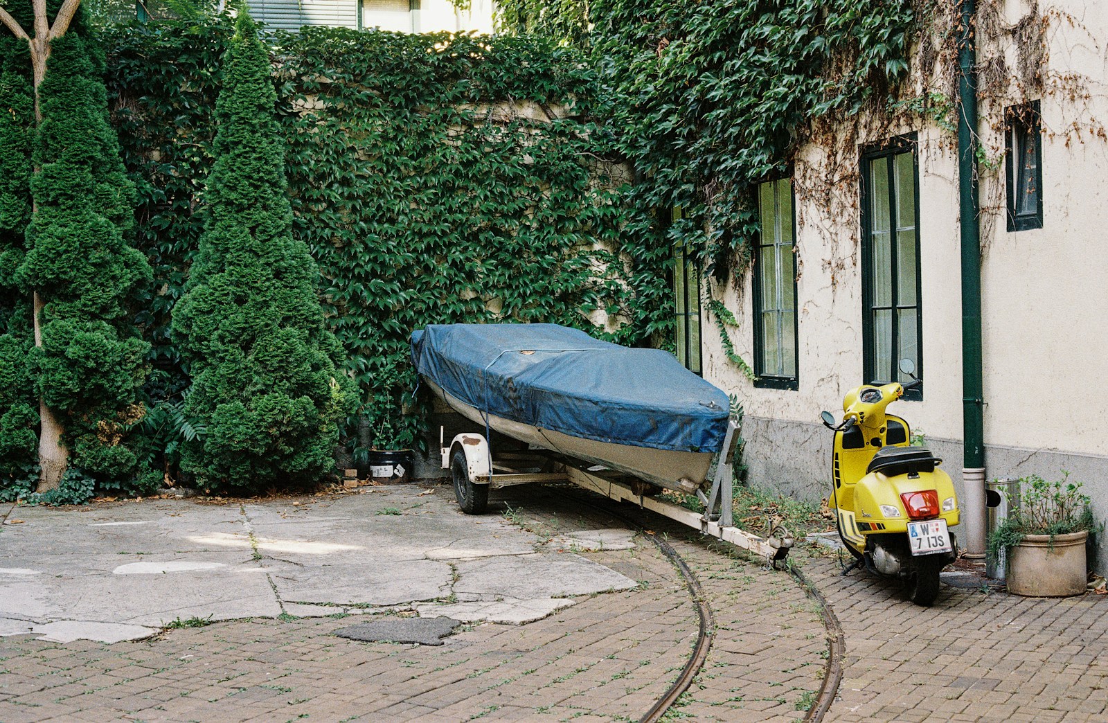 A motor bike parked next to a boat on a trailer