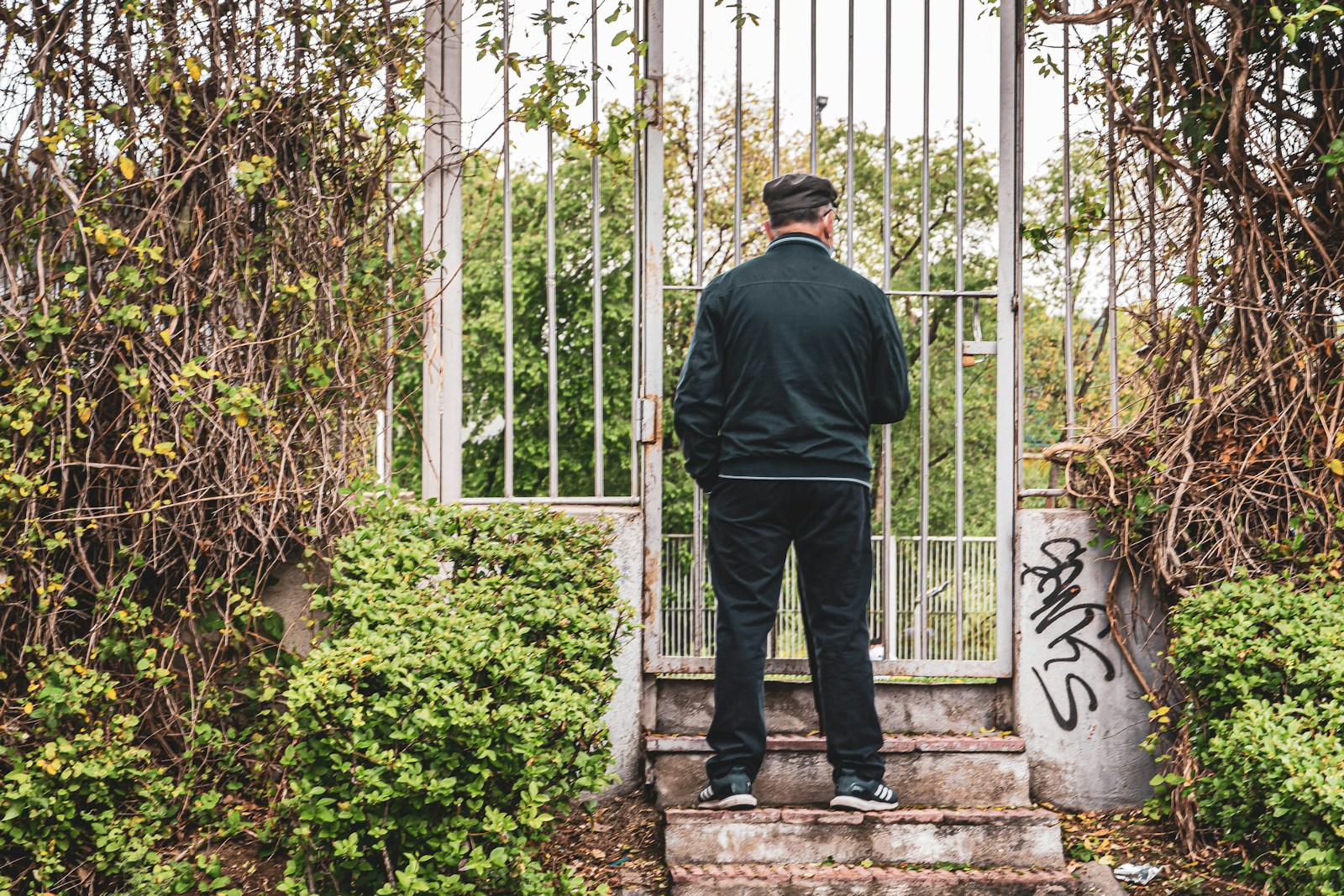 man in gray dress shirt and black pants standing on gray concrete stairs
