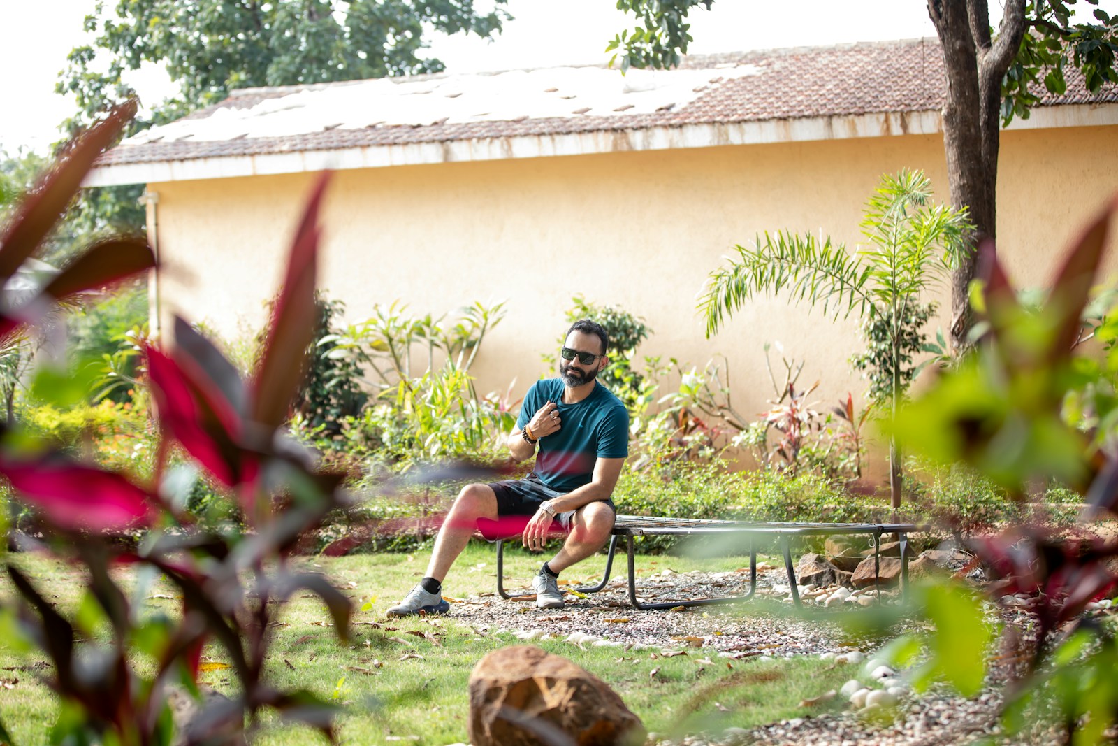 a man sitting on a bench in a garden