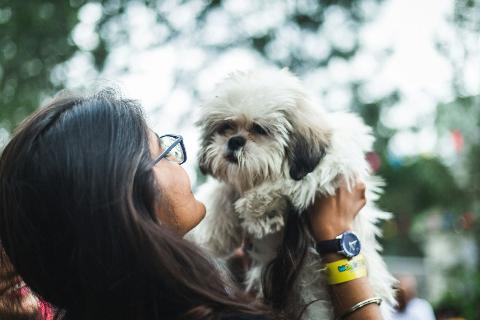 a woman holding a small white dog in her arms