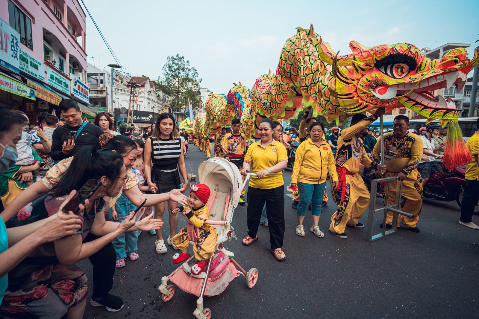 Vibrant street scene of a Lunar New Year parade with dragon dancers in Ho Chi Minh City, Vietnam.