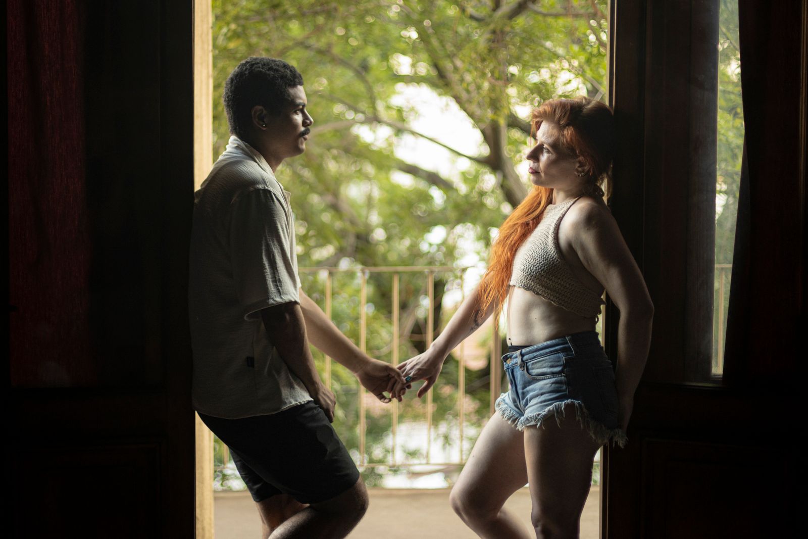 A couple shares an intimate moment indoors as they hold hands in Buenos Aires.