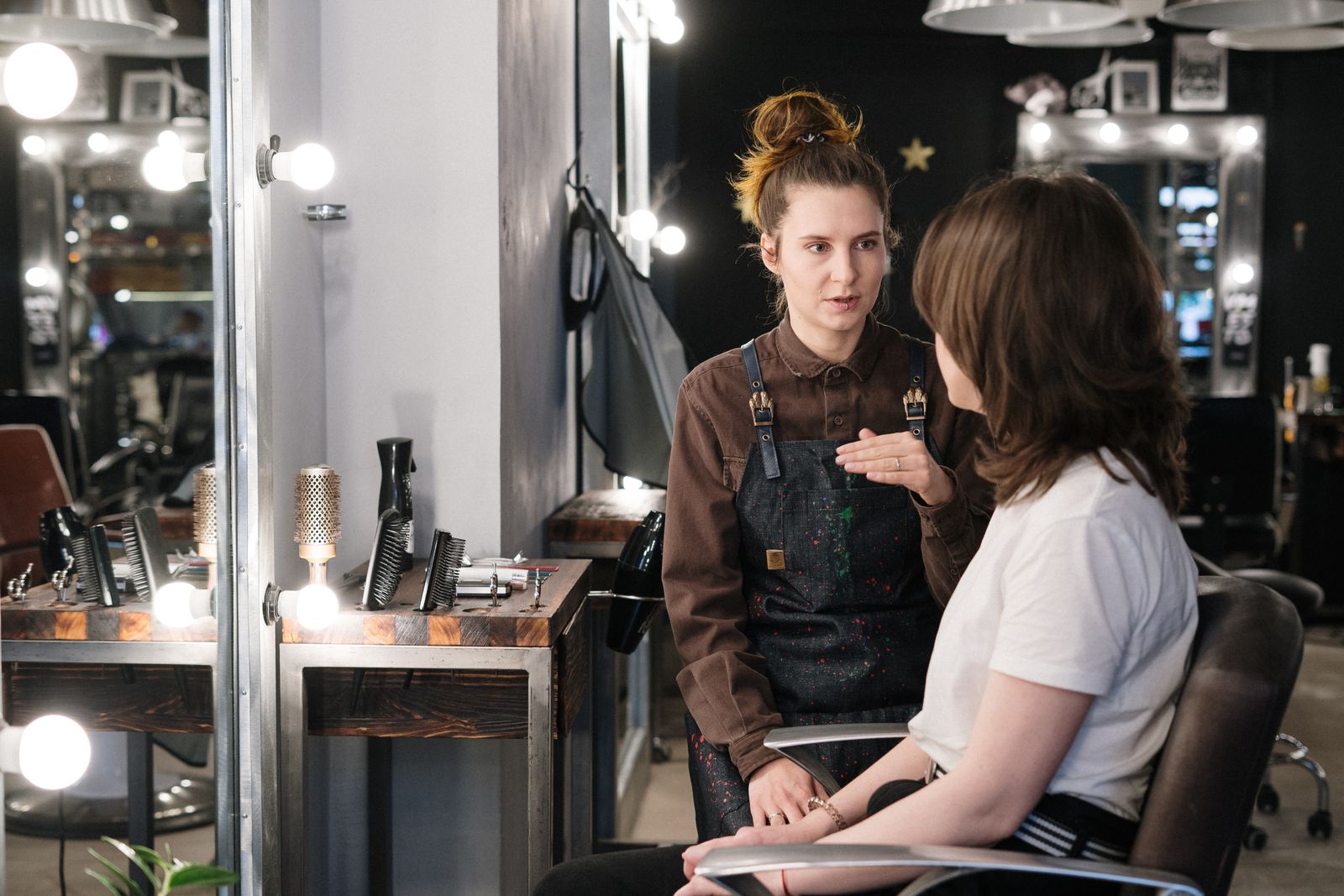 Hair stylist providing consultation to client in a modern salon setting.