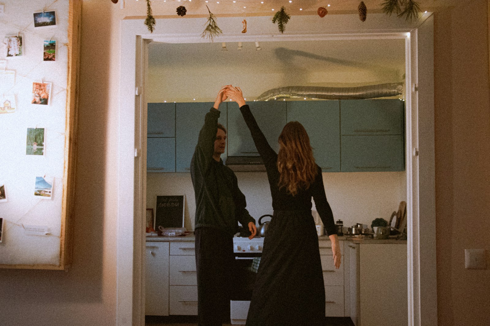 Couple dancing in a kitchen with fairy lights