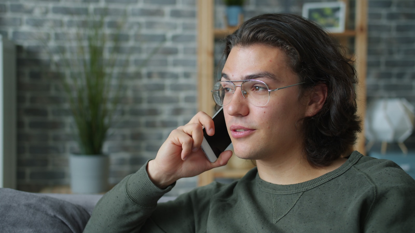 Man wearing glasses talking on a smartphone.