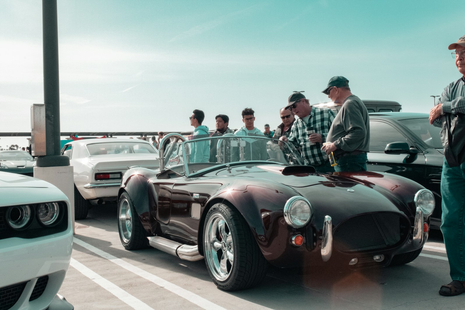 a group of men standing around a car in a parking lot