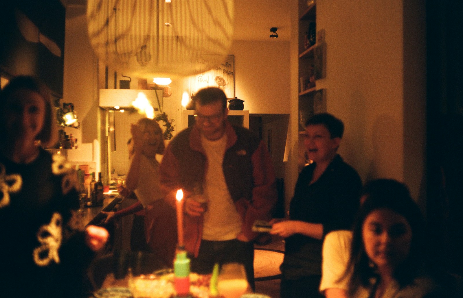 People gathered around a table with a lit candle.