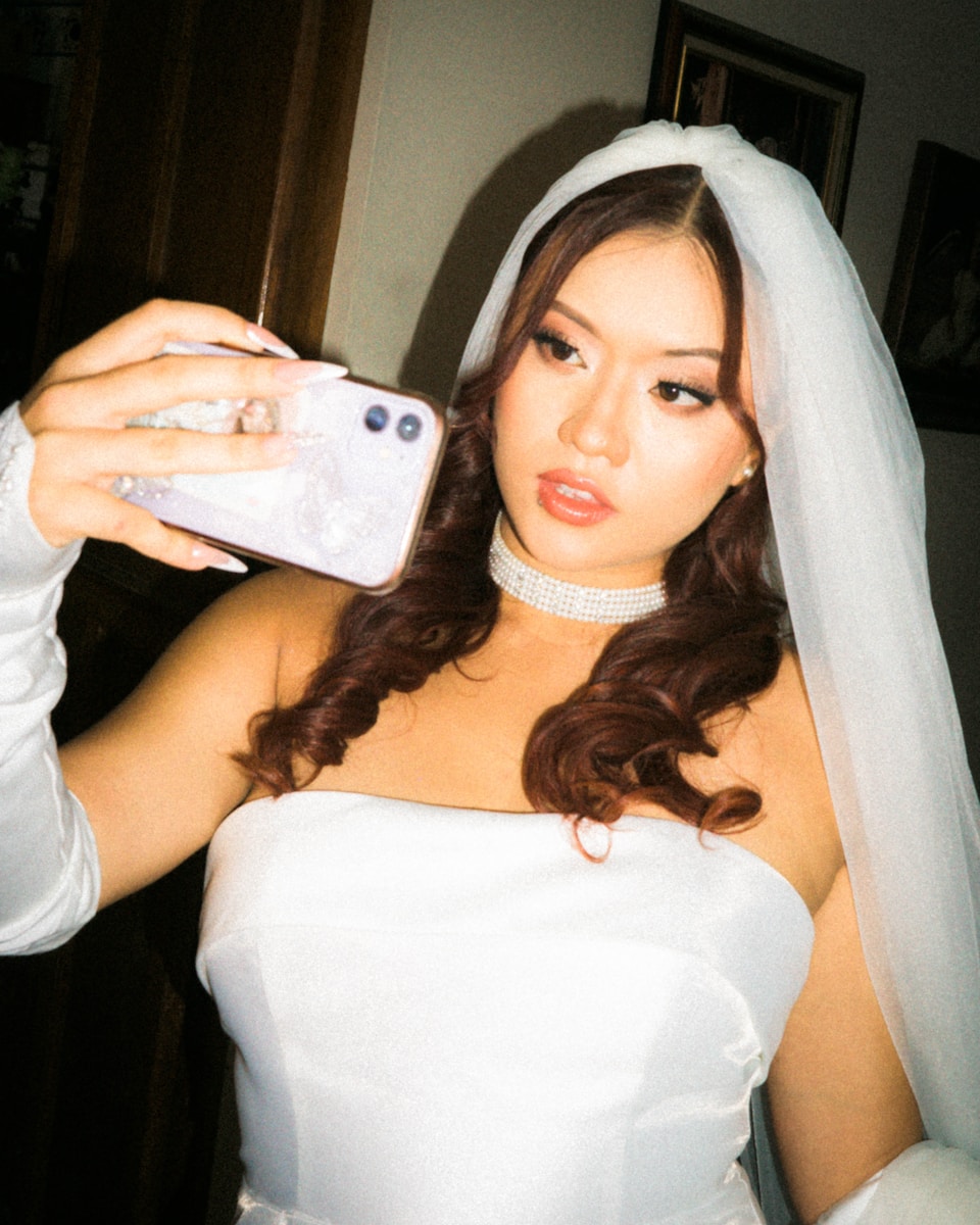 a woman taking a picture of herself in her wedding dress