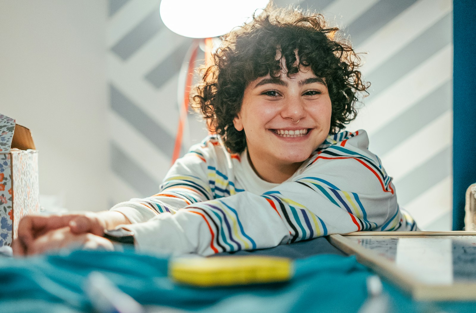 a young boy smiling while sitting at a table