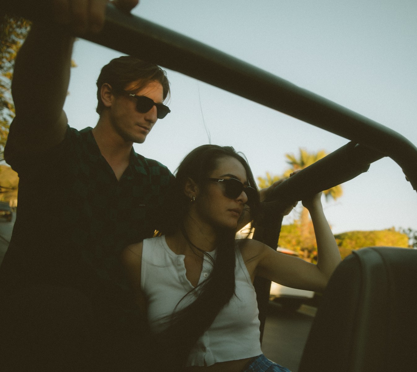 woman in white shirt sitting beside man in black button up shirt