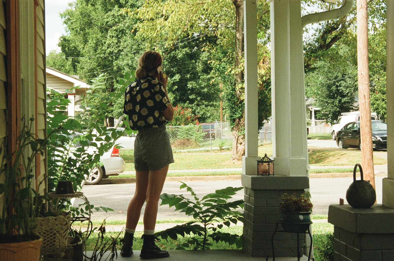 woman on phone standing near plant