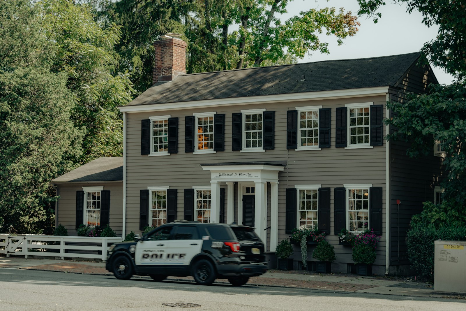 A police car parked in front of a house
