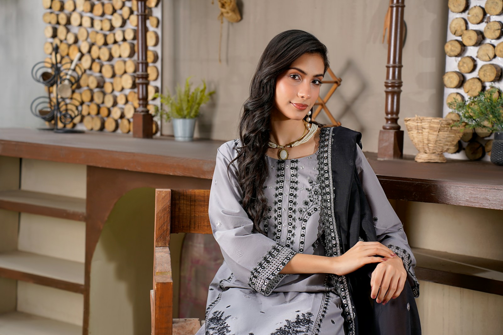 A woman in a gray outfit with black accents sits.