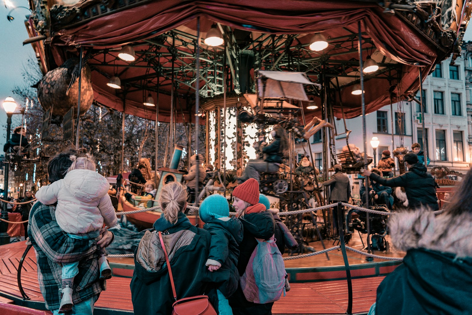 A group of people standing around a merry go round