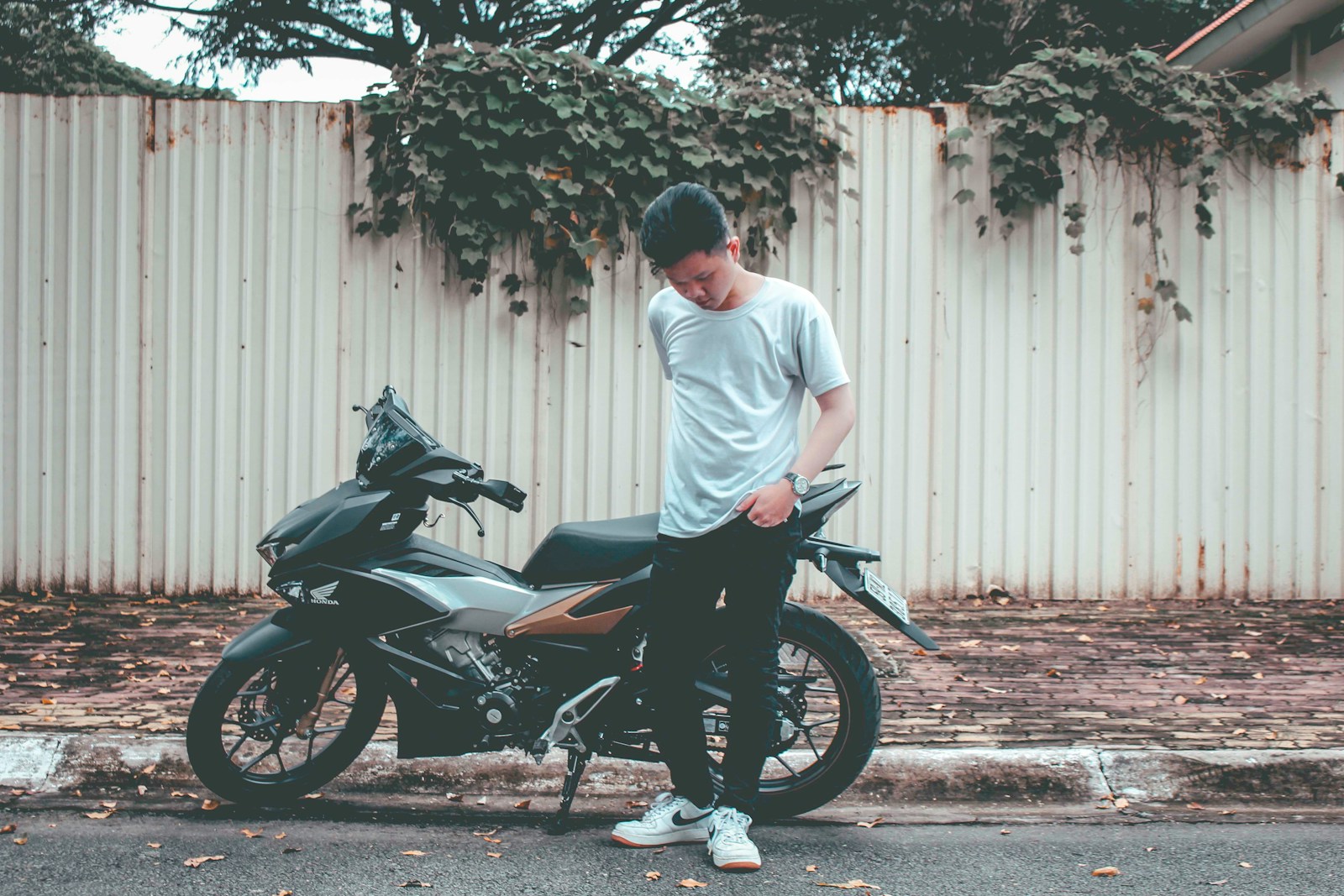 man standing front of motorcycle at daytime