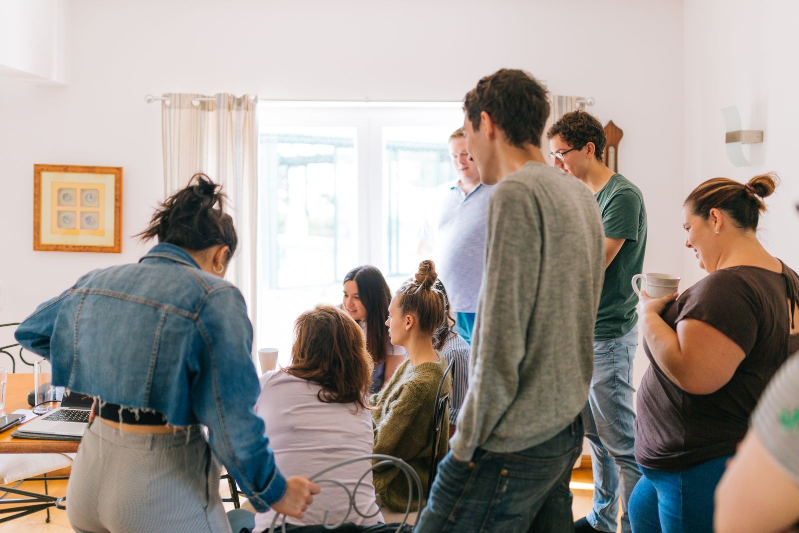 A group of adults collaborating around a table in a bright room, promoting teamwork and creativity.