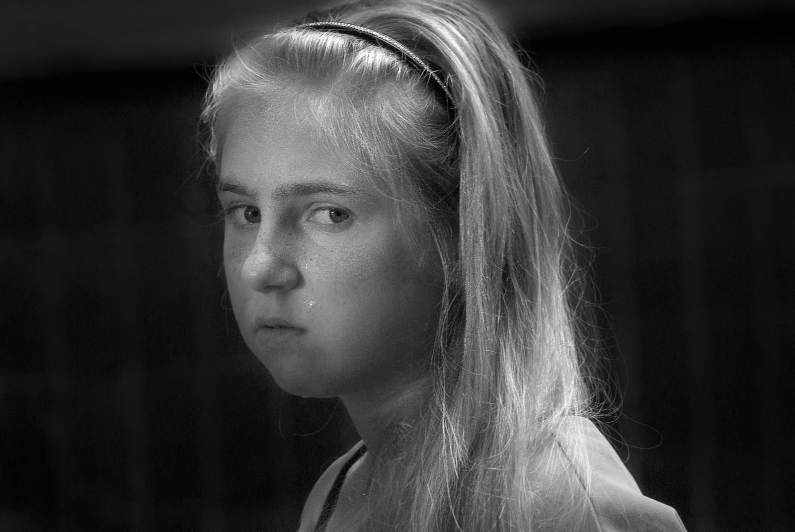 A touching black and white portrait capturing the sadness of a young girl.