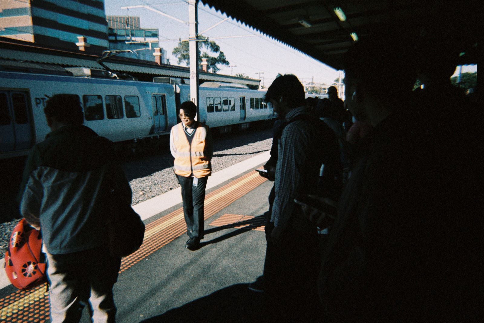 Commuters waiting for a metro train at a station in Melbourne, capturing morning bustle.